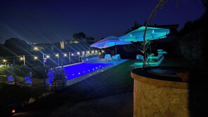 Una piscina al aire libre de temporada, sombrillas