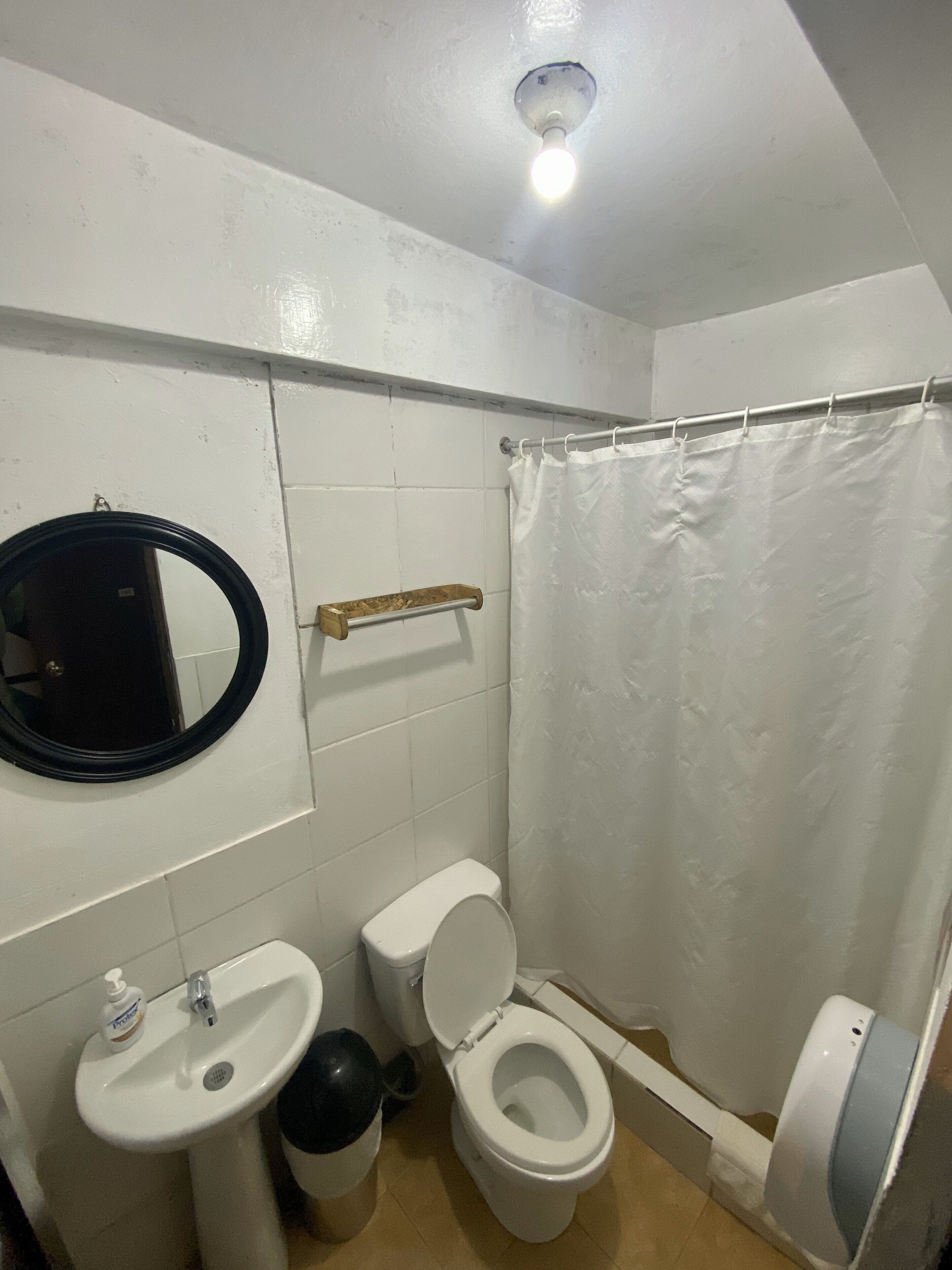 A small bathroom with a toilet, sink, and mirror.