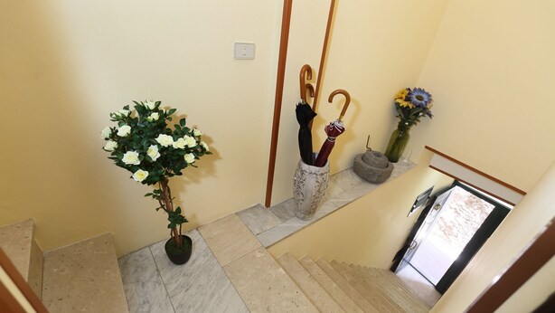 Een trap met een potplant en een vaas met bloemen.