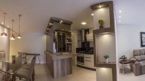 Un espace de vie moderne comprenant un coin repas, une cuisine et un coin salon.