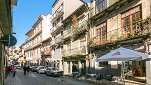 A narrow street lined with multi-story buildings, some with balconies and outdoor seating areas. - North Star Flats - Ribeira & Cellars (Vila Nova de Gaia)
