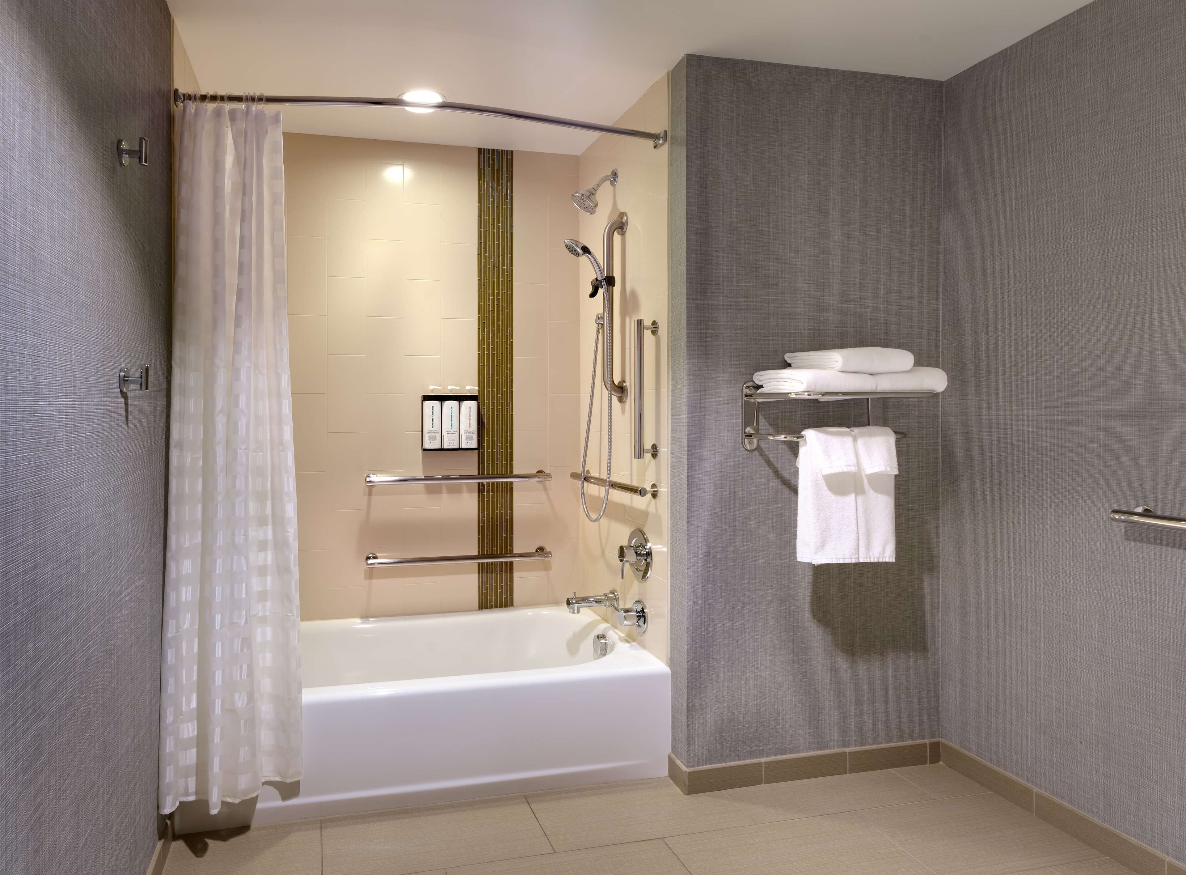 Un baño moderno con bañera, ducha y toallero.