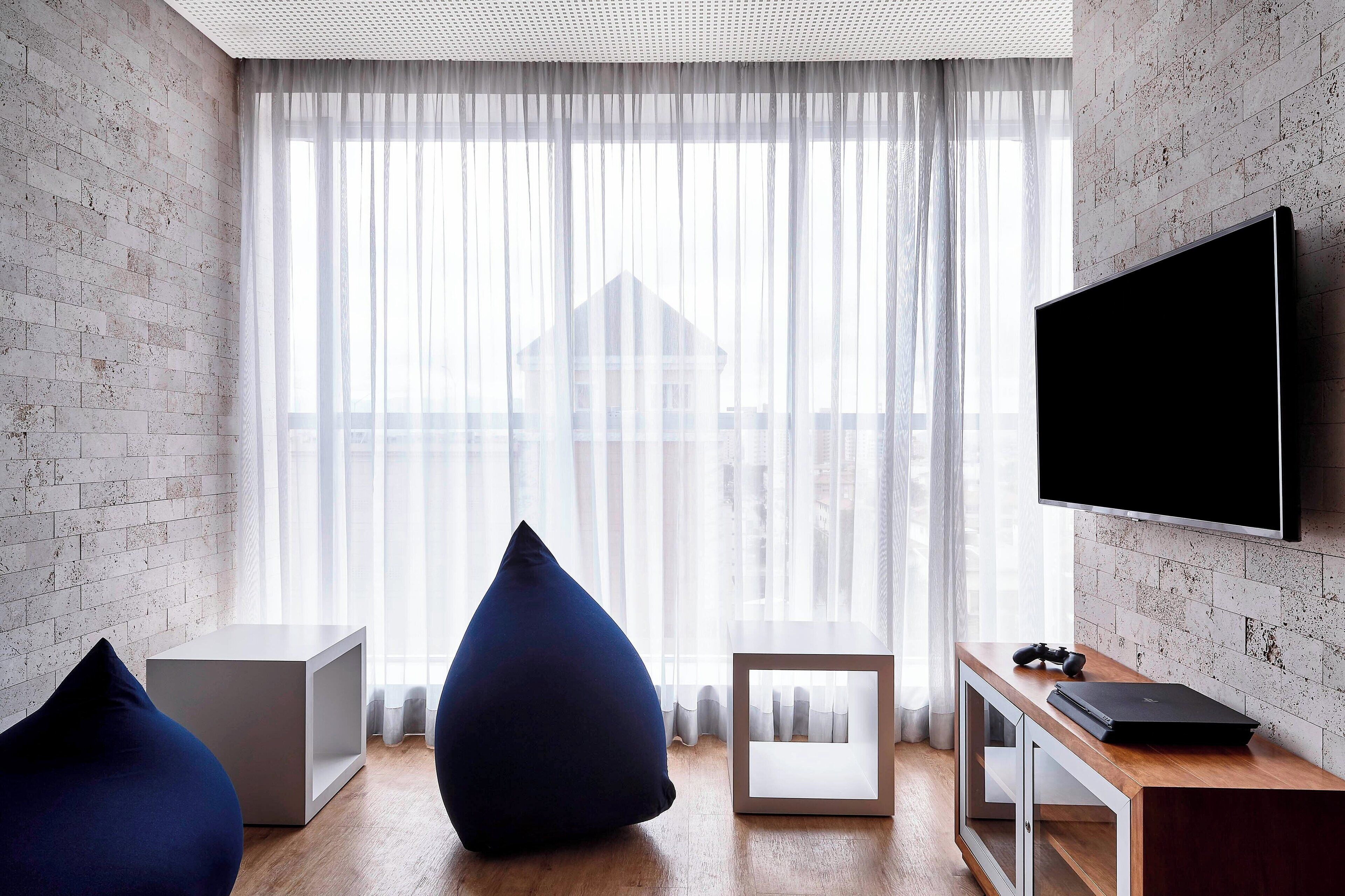 Una sala de estar moderna con un ventanal grande, un televisor de pantalla plana y una mesa de centro de madera.