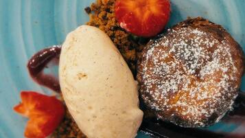 A dessert plate with a scoop of ice cream, a piece of cake, and a strawberry.