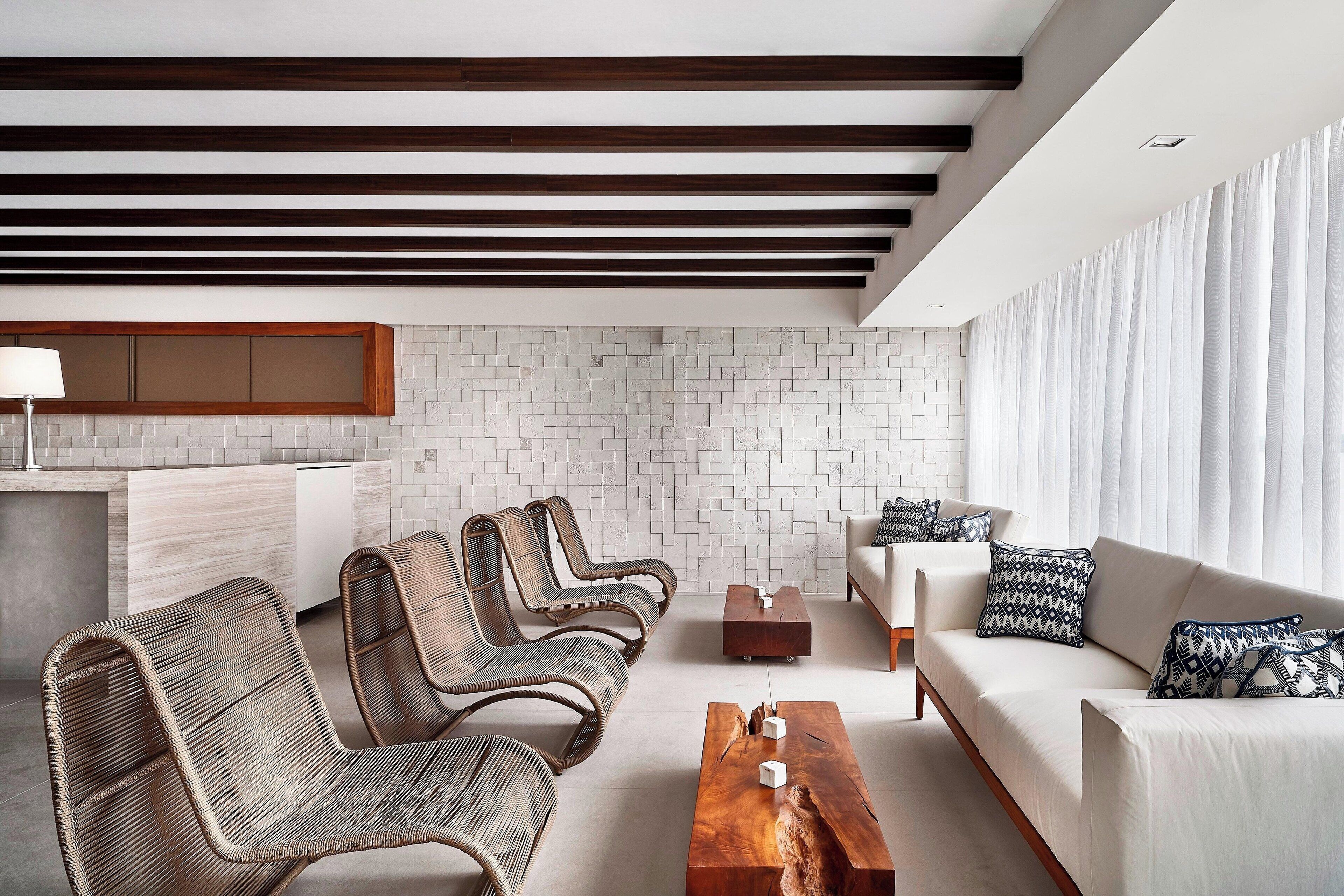 Una sala de estar moderna con un sofá, sillas y una mesa de centro.