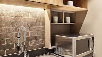 Una cocina moderna con electrodomésticos de acero inoxidable, un lavamanos doble y armarios de madera.