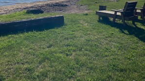 A grassy area with a bench and a table near a body of water. - Noc's Landing: Sun-Soaked Days & Starry Nights – Your Summer Escape Awaits! (Rapid River)