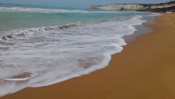 Une plage où les vagues se brisent près du rivage.