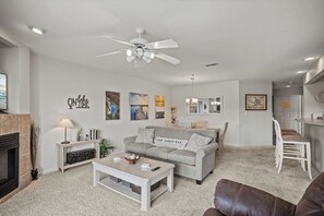 Un salon avec un canapé, une table basse et un ventilateur de plafond.