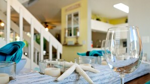 Une table à manger agrémentée d’un verre à vin, d’une bougie et d’une étoile de mer en guise de décoration.