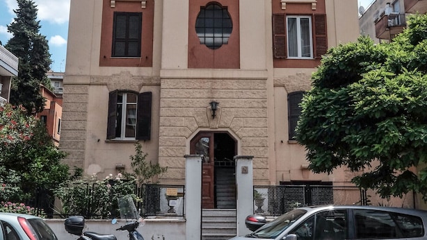 Un bâtiment à la façade symétrique, doté de grandes fenêtres et d’une entrée centrale.
