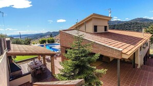 A house with a swimming pool, a covered patio, and a view of the mountains. - Stunning modern villa - just half hour to Barcelona! (Caldes De Montbui)