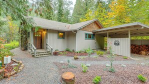 A rustic cabin with a stone foundation, wooden siding, and a covered porch. - Fishing & Rafting: McKenzie River Cabin! (Mckenzie Bridge)