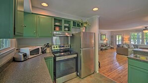A kitchen with green cabinets, a stainless steel refrigerator, a built-in oven, and a microwave. - Harrison Lakefront Cottage w/ Private Dock! (Harrison)