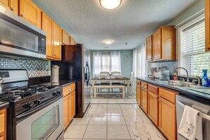 Enjoy cooking in this well-equipped kitchen with a central island, sink, and stainless steel range hood.