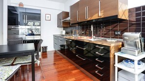 A modern kitchen with dark wooden cabinets, stainless steel appliances, and a wooden countertop. - Enjoy the Sunset on Your Vatican Terrace (Roma)