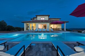 A modern house with a swimming pool, lounge chairs, and a patio area. - Villa Karli (Sutivanac)