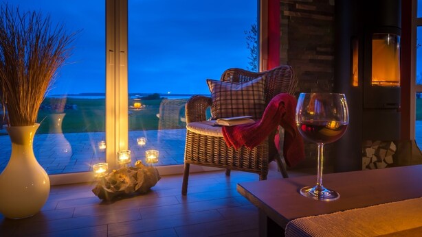 A cozy seating area with wicker furniture, a glass of red wine, and a view of the outdoors. - located at the sea, stunning view over Hiddensee and the iconic lighthouse (Trent OT Vaschvitz)
