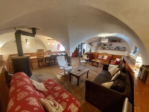 Ein gemütliches Interieur mit Essbereich, einer Couch und einem Kamin.