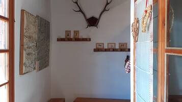Une pièce avec un plafond en bois, une tête de cerf accrochée au mur et un banc.