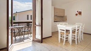 A modern kitchen with white cabinets and a tiled backsplash. - Apartment Rosa Bourbon With Pool (Lazise)