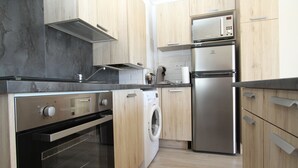 A modern kitchen with stainless steel appliances, wooden cabinets, and a built-in oven.