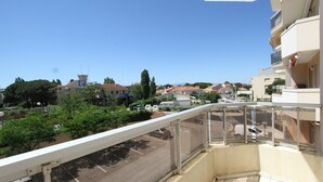 A balcony with a view of a parking lot and buildings.
