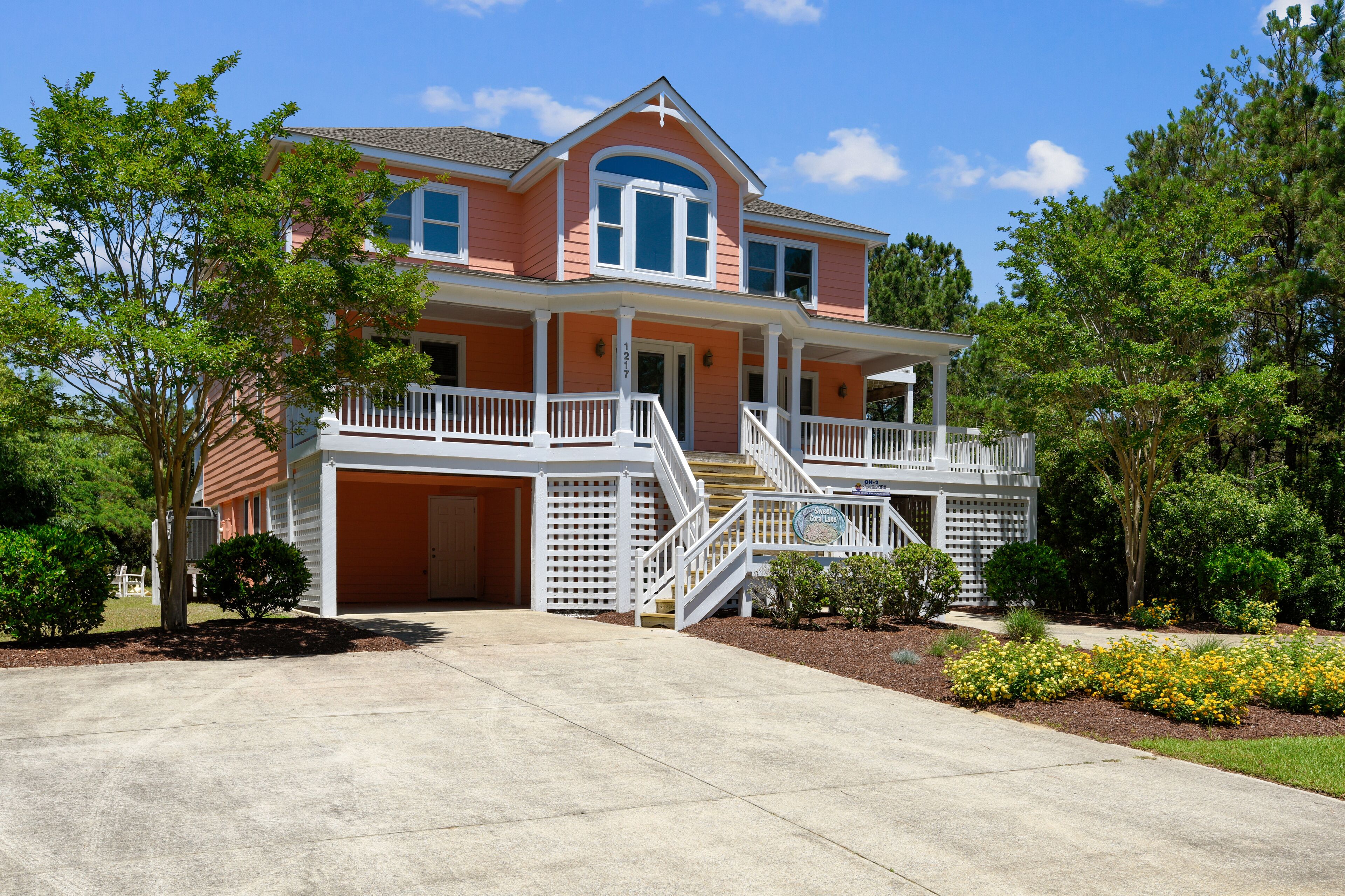 A two-story house with a front porch, a garage, and a well-maintained lawn.