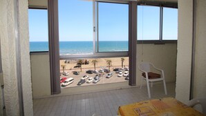A balcony with a view of the beach and parked cars. - 2 room apartment with sea view and parking (Canet-en-Roussillon)