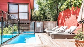 Uma área de piscina com espreguiçadeiras e um deck de madeira.