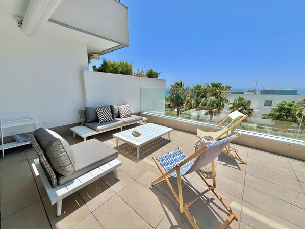 A rooftop terrace with a sofa set, a coffee table, and a lounge chair.
