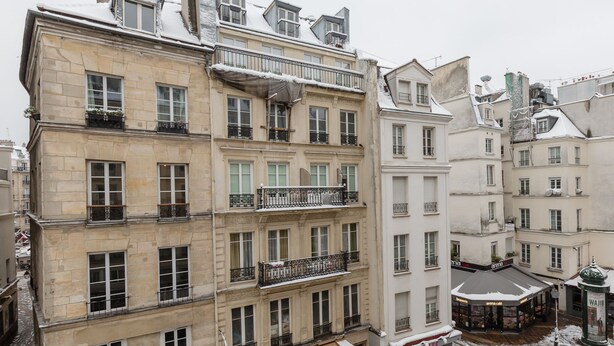 A multi-story building with balconies, large windows, and a cafe at the ground level. - Pompidou Hideaway, by Veeve (Paris)