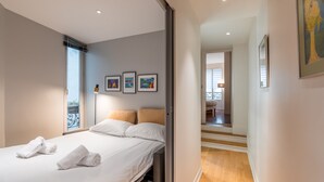 A hotel room with a bed, white linens, a window, and framed artwork on the wall. - Pompidou Hideaway, by Veeve (Paris)