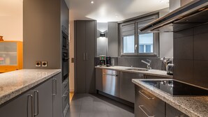 A modern kitchen with stainless steel appliances, grey cabinetry, and a granite countertop. - Pompidou Hideaway, by Veeve (Paris)