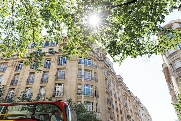 A multi-story building with a classical architectural style, featuring balconies and large windows. - Avenue to the Eiffel Tower, by Veeve (Paris)