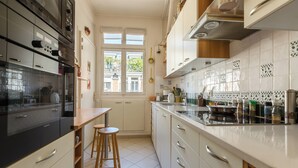 A modern kitchen with a large island, white cabinetry, and a window providing natural light.
