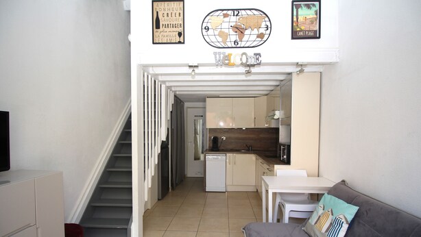 A compact living space with a staircase leading to a kitchen area. - Maisonette T2  et parking dans résidence avec piscine (Canet-en-Roussillon)