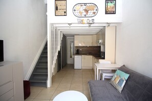 Un espace de vie compact avec un escalier menant à une cuisine.