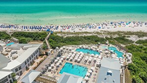 Een resort met diverse zwembaden, toegang tot het strand en verschillende strandparasols.