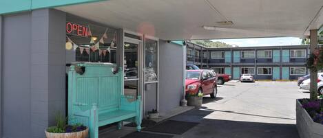 Un motel con fachada turquesa, un letrero que dice 'Precaución, altura limitada 7 pies' y un letrero que indica 'ABIERTO'.