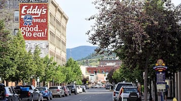 Une rue bordée de voitures garées et une grande enseigne publicitaire annonçant une boulangerie du quartier.