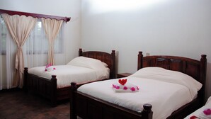 Two wooden beds with white linens, a window with sheer curtains, and a wooden ceiling. - Hotel Huella Lenca (Yamaranguila)