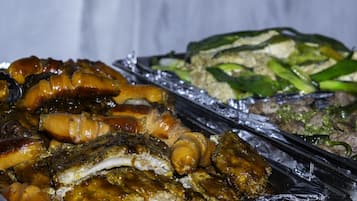 Un bufé con diversos platos, incluyendo carnes asadas y vegetales.