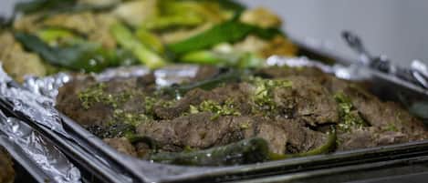Una bandeja con carne y verduras cocinadas, posiblemente para una comida.