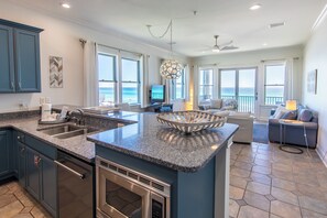 A modern kitchen with granite countertops, stainless steel appliances, and a large island.