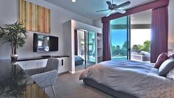 Een moderne hotelkamer met een groot bed, een flatscreen televisie, een plafondventilator en een balkon met uitzicht op de omgeving.
