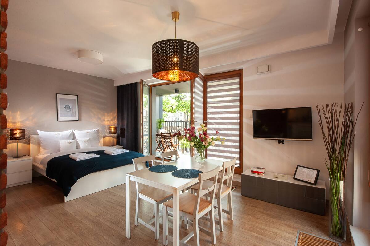 Un dormitorio moderno con cama, mesitas de noche, escritorio y televisor.