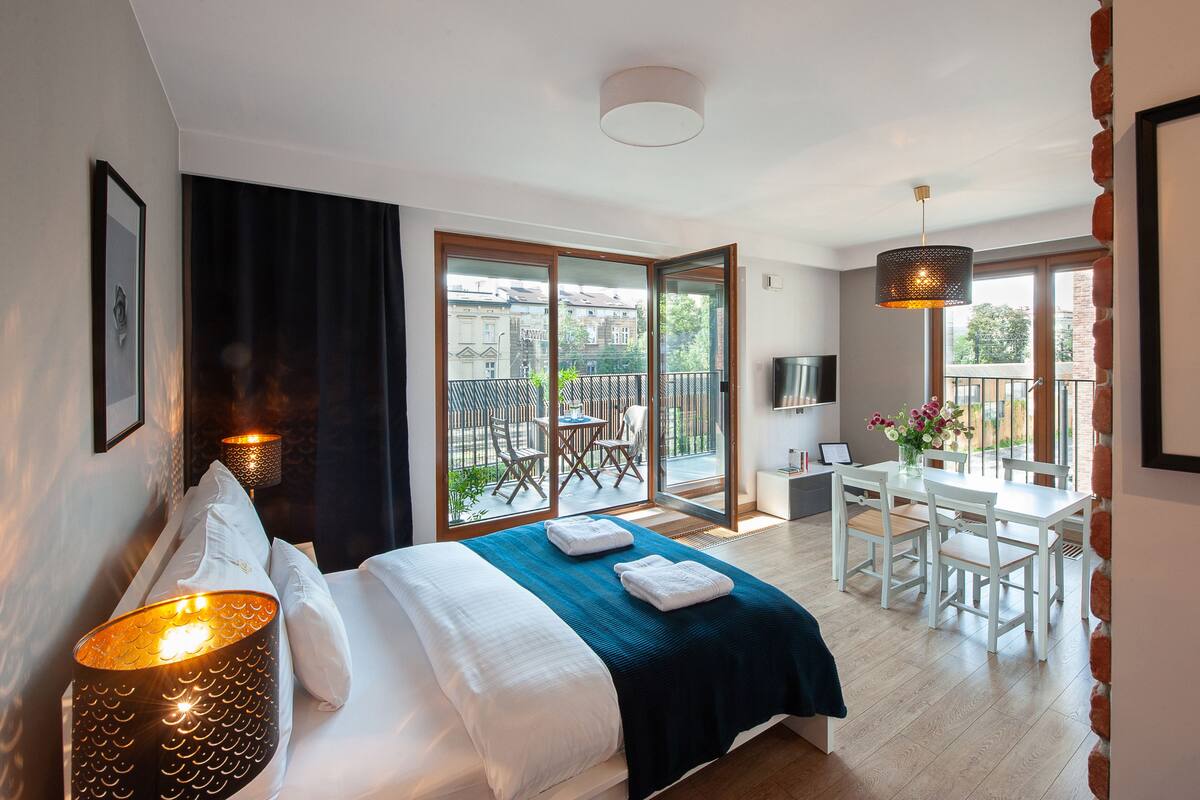 Una habitación de hotel con cama, escritorio y balcón.