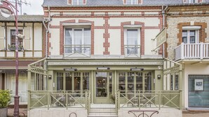 A two-story building with a ground-floor restaurant and upper-floor hotel rooms. - Les Cabines (Houlgate)