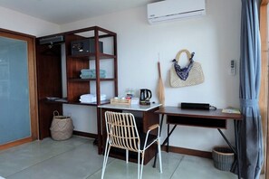 A compact room with a desk, chair, wardrobe, and a hanging bag. - Tamarina Bed and Beyond (Koh Samui)